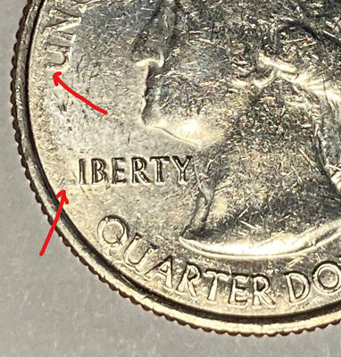 2011 quarter strike-through error showing depression in coin surface where foreign material was impressed during striking